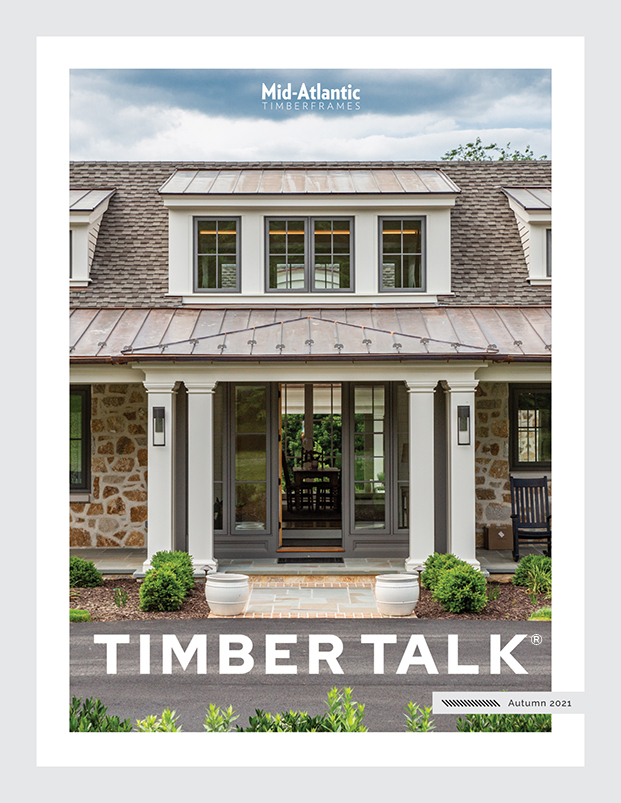 Front cover of TIMBER TALK magazine, Autumn 2021, featuring a porch entrance of a stone house with a gray roof, white columns, glass doors, and landscaped greenery. Mid-Atlantic Timberframes branding at the top.